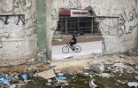Un Palestinien passe en vélo devant l'hôpital Nasser endommagé à Khan Younès, dans le sud de la bande de Gaza, le 2 mai 2024
