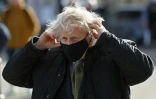 Le Premier ministre britannique Boris Johnson ajuste son masque lors d'un déplacement à Truro, sud-ouest de l'Angleterre, le 7 avril 2021