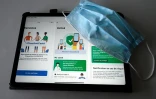 Masque et tablette connectée à l'application #TousAntiCovid, qui a succédé à StopCovid