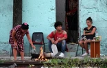 Des habitants cuisinent sur un feu de bois devant leur maison à La Havane pendant une panne de courant à Cuba, le 15mars 2025