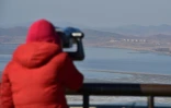 Un visiteur regarde grâce à des jumelles la Corée du Nord depuis Paju point d'observation dans la zone démilitarisée entre les deux Corée, le 8 janvier 2016