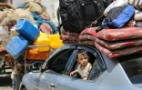 Un enfant regarde par la fenêtre d'une voiture alors que des Palestiniens fuient avec leurs biens Deir el-Balah, dans le centre de la bande de Gaza, le 16 août 2024