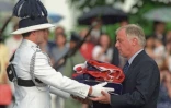 Chris Patten (d), le 28e et dernier gouverneur colonial britannique de Hong Kong, reçoit l'Union Jack, lors d'une cérémonie d'adieux à l'occasion de la rétrocession de la ville à la Chine, le 30 juin 1997 à Hong Kong
