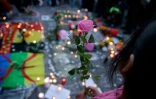 Une fillette tient dans ses mains une rose et se mêle aux hommages aux victimes des attentats, place de la Bourse à Bruxelles, le 22 mars 2016