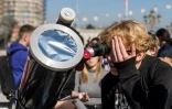 Un jeune homme utilise un télescope pour admirer une éclipse patielle, le 25 octobre 2022 à Skopje, en Macédoine du Nord
