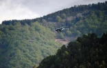 Un hélicoptère survole une zone forestière des Cévennes, le 12 mai 2021, à la recherche du fugitif qui a tué deux personnes