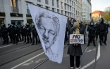 Un manifestant contre le pass sanitaire tient un drapeau représentant Julian Assange le 6 novembre 2021 à Leipzig, en Allemagne