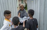 Trois jeunes garçons proposent des oeuvres de leur création en porte-à-porte à l'occasion du nouvel an éthiopien, Enkutatash, à Addis-Abeba, le 11 septembre 2022 