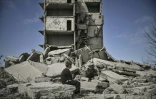 Un garçon assis devant un immeuble détruit par un bombardement russe à  Kramatorsk, dans la région de Donbass, dans l'est de l'Ukraine, le 25 mai 2022