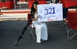 Une femme attend un membre de sa famille, militaire embarqué à bord du porte-avions USS Abraham Lincoln, dans le port de San Diego, en Californie, le 8 octobre 2026