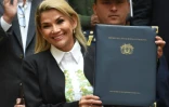 La présidente bolivienne par interim Jeanine Anez montre le document signé convoquant de nouvelles élections présidentielle et législatives en Bolivie, à La Paz le 24 novembre 2019