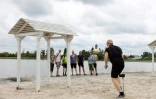 Des cyclistes font une photo de groupe sur la plage de Sloviansk, dans l'est de l'Ukraine, le 22 juin 2022