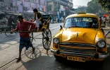 Un taxi Ambassador à côté d'un rickshaw dans une rue de Calcultta, le 28 janvier 2025 en Inde
