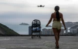 Une touriste se fait filmer par un drone sur le toit d'une maison dans la favela de Rocinha, à Rio de Janeiro, au Brésil, le 5 mars 2026