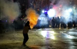 Un manifestant tire des fusées de feu d'artifice sur la police lors de la cinquième nuit consécutive de mobilisation contre le report des négociations d'adhésion à l'UE, le 2 décembre 2024 à Tbilissi, en Géorgie