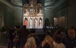 Des visiteurs devant "L'Adoration de l'Agneau mystique", chef-d'oeuvre de la peinture primitive flamand, lors de sa présentation  après sa restauration le 12 octobre 2016  à la cathédrale Saint Bavo à Gand