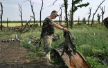 Un soldat ukrainien inspecte les débris d'un char russe, près de Mykolaïv, dans le sud de l'Ukraine, le 12 juin 2022