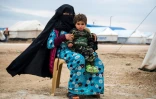 Une femme et un enfant se tiennent devant une tente dans le camp de déplacés d'Al-Hol, dans la province de Hassaké, dans le nord de la Syrie, le 7 février 2019