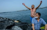 Un septuagénaire lève les bras au ciel après un baignade dans le Bosphore, le 17 mai 2020 à Istanbul