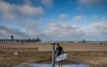 Un surfeur sur la plage d'Huntington Beach, le 2 mai 2020 en Californie