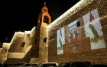 La vidéo d'un discours du président palestinien Mahmoud Abbas, projetée sur un mur près de la Basilique de la Nativité à Bethléem (Cisjordanie occupée), le 24 décembre 2020