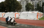 Des migrants près d'un futur camp de migrants sur un terrain de sport dépendant de l'Université Panthéon-Assas le 22 août 2017 