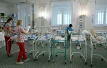 Des infirmières s'occupent de nouveaux-nés parmi la centaine de bébés nés de mères porteuses bloqués en Ukraine par la pandémie, à l'Hôtel Venice à Kiev le 15 mai 2020