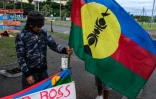 Un homme tient un drapeau kanak sur un campement indépendantiste à Rivière Salée en Nouvelle-Calédonie, le 12 juin 2024