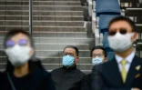 Des propriétaires de chevaux qui participent à une course à Hong Kong portent des masques de protection dontre le coronavirus, le 16 février 2020  