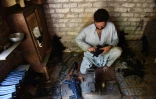 Un Pakistanais fabrique des répliques de pistolets dans un atelier du bazar de Darra Adamkhel (près de Peshawar), le 6 juin 2016