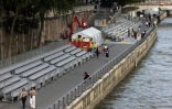 Des stands en cours d'installation sur le parcours de la cérémonie d'ouverture en plein air sur la Seine des Jeux olympiques de Paris 2024, à Paris, le 10 juillet 2024