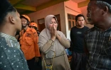 Deux jours après l'effondrement d'une école islamique à Sidoarjo en Indonésie, des proches d'élèves portés disparus se réunissent pendant que les secouristes tentent de retrouver des survivants le 1er octobre 2025.