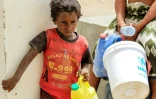 Un enfant yéménite attend son tour pour remplir de l'eau dans un camp de déplacés installé à Khokha pour les habitants ayant fui la ville proche de Hodeida, cible d'une offensive gouvernementale, le 22 juin 2018