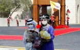 Des enfants irakiens en costume traditionnel arabe (G) et kurde (D) attendent l'arrivée du pape devant le palais présidentiel à Bagdad le 5 mars 2021