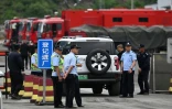 Des policiers devant la route menant à la mine de charbon de Liushenyu, où un coup de grisou dévastateur a fait au moins 82 morts, le 24 mai 2026 dans le district administratif de Qinyuan, dans la province chinoise septentrionale du Shanxi