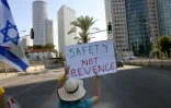 Une Israélienne brandit une pancarte réclamant "Sécurité, pas de vengeance", le 16 octobre 2023, pendant un sit-in permanent à Tel Aviv devant le ministère de la Défense depuis le massacre perpétré en Israël le 7 octobre par le Hamas qui a fait 1.400 morts, surtout des civils israéliens