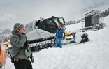 Un membre de l'organisation et un chasse-neige sur l'aire d'arrivée des finales de la Coupe du monde de ski alpin à Lenzerheide en Suisse, le 16 mars 2021