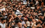 Des Palestiniens portent le corps de deux victimes des frappes israéliennes à Gaza, le 5 août 2022