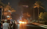 Des partisans du Hezbollah bloquent la route menant à l'ancien aéroport, dans la banlieue sud de Beyrouth, en brûlant des pneus pour protester contre l'accord trilatéral signé entre les Etats-Unis, Israël et le Liban le 27 juin 2026