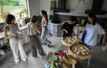 Chen Yani (d), fondatrice du lieu "L'Univers imaginaire de Keke", déjeune avec des participantes dans la cuisine du gîte rural, le 14 juillet 2025 à Hangzhou, dans la province du Zhejiang, dans l'est de la Chine
