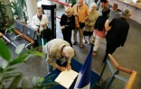 Des habitants font la queue pour signer le registre de condoléances le 27 juillet 2016 à la mairie deSaint-Etienne-du-Rouvray
