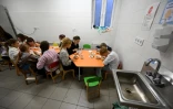 Des écoliers déjeunent dans la cantine d'un abri au sous-sol de leur établissement scolaire pendant une alerte aérienne dans la banlieue de Kiev, le 20 octobre 2026