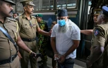 Des policiers escortent les accusés impliqués dans les attentats de Pâques 2019, lors du prononcé du verdict à la Haute Cour de Colombo, le 22 septembre 2026 au Sri Lanka