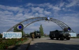 Des véhicules militaires russes traversent l'entrée de la centrale nucléaire de Zaporijjia en Ukraine le 1er mai 2022