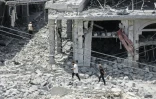 Des habitants déplacés, de retour à Nabatiyé, se fraient un chemin au milieu des décombres d'un immeuble détruit, le 15 juin 2026 dans le sud du Liban