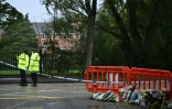 Des policiers près de fleurs déposées à l'extérieur de la synagogue d'Heaton Park, à Crumpsall, au nord de Manchester, le 4 octobre 2025 en Angleterre