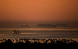 Des porte-conteneurs attendent leur entrée dans les ports de Los Angeles et de Long Beach à l'aube, le 15 octobre 2021