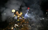 Des secouristes ukrainiens éteignent un incendie dans une maison après une attaque de drones à Kharkiv le 3 mai 2025