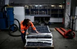 Une employée de l'entreprise Envie 2E récupère les pièces de vieux panneaux solaires qui seront recyclées, le 13 novembre 2023 à Saint-Loubès, en Gironde
