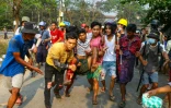 Evacuation d'un blessé durant une manifestation contre le coup d'Etat militaire en Birmanie, à Rangoun le 14 mars 2021